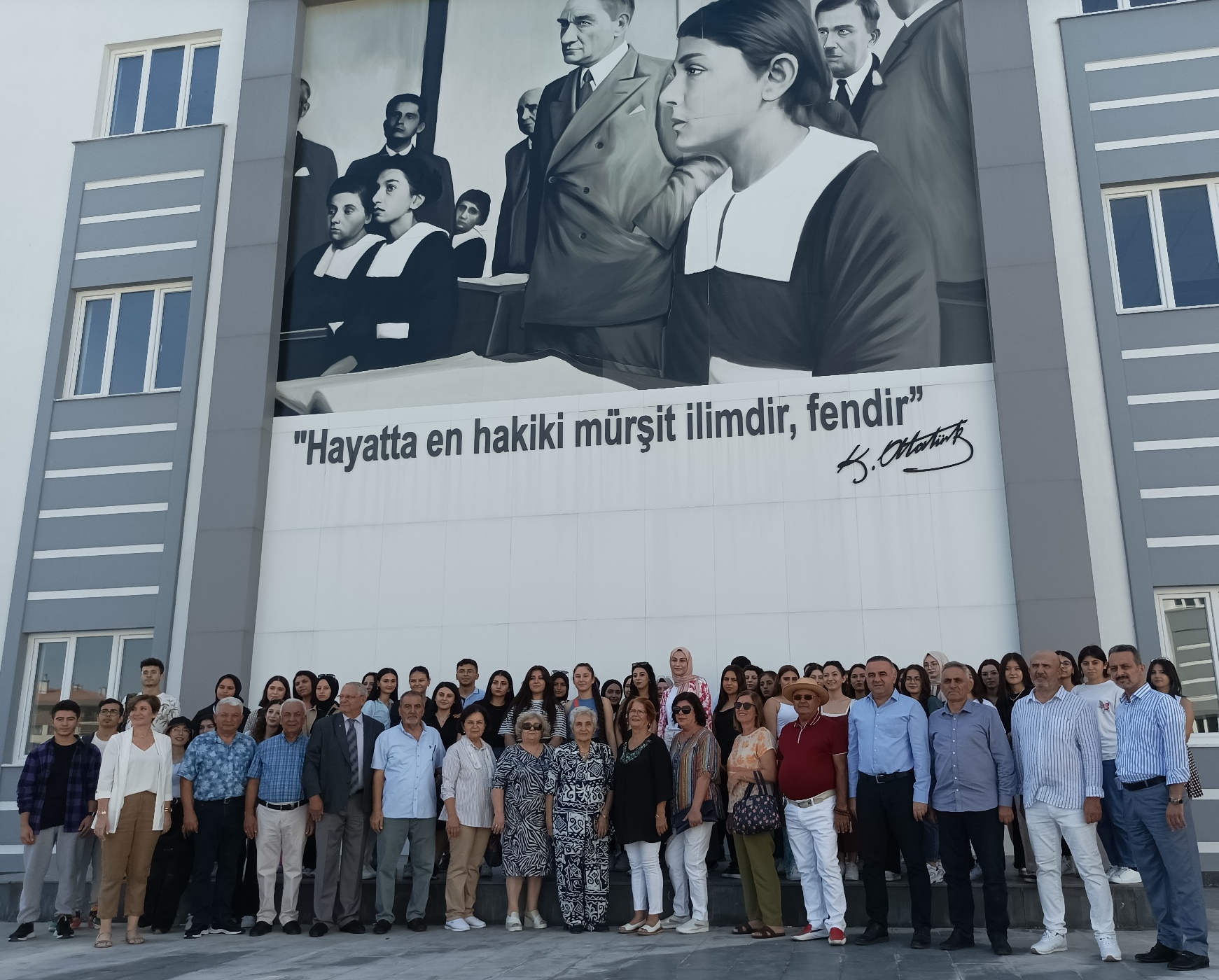 Öğrencilerle birlikte bahçede Atatürk portresi önünde