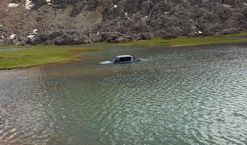 Göletten geçmek isterken aracıyla mahsur kaldı